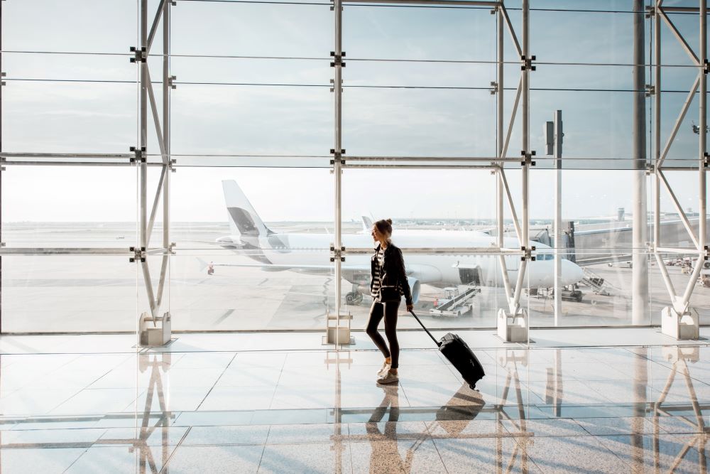 Frau mit Koffer am Flughafen