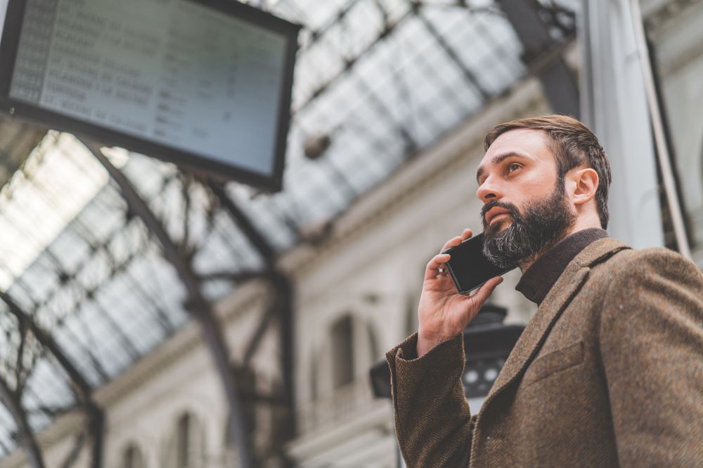 Geschäftsreisender telefoniert am Bahnhof Travel Risk Management