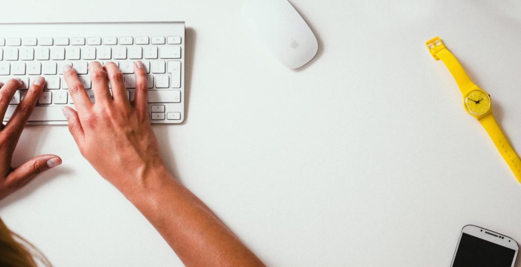 person typing keyboard desk