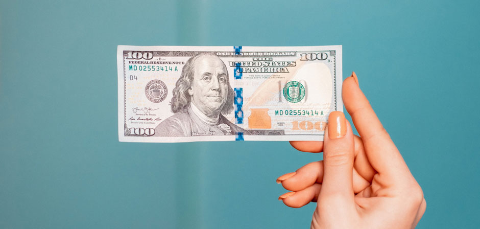hand holding 100 dollars