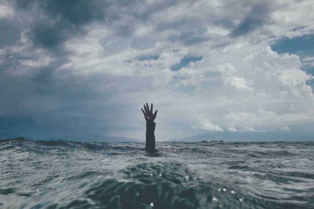 Stress metaphor hand emerging from sea