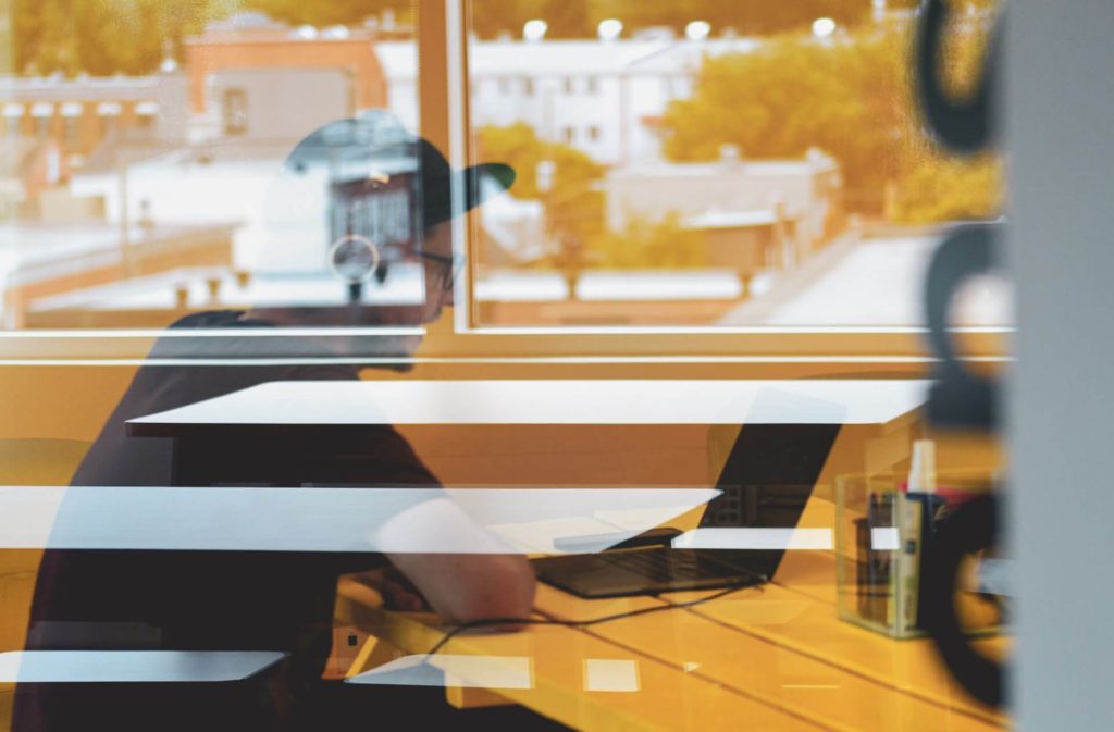 guy on laptop through window