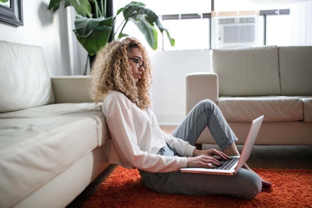 woman working on laptop sitting on floor